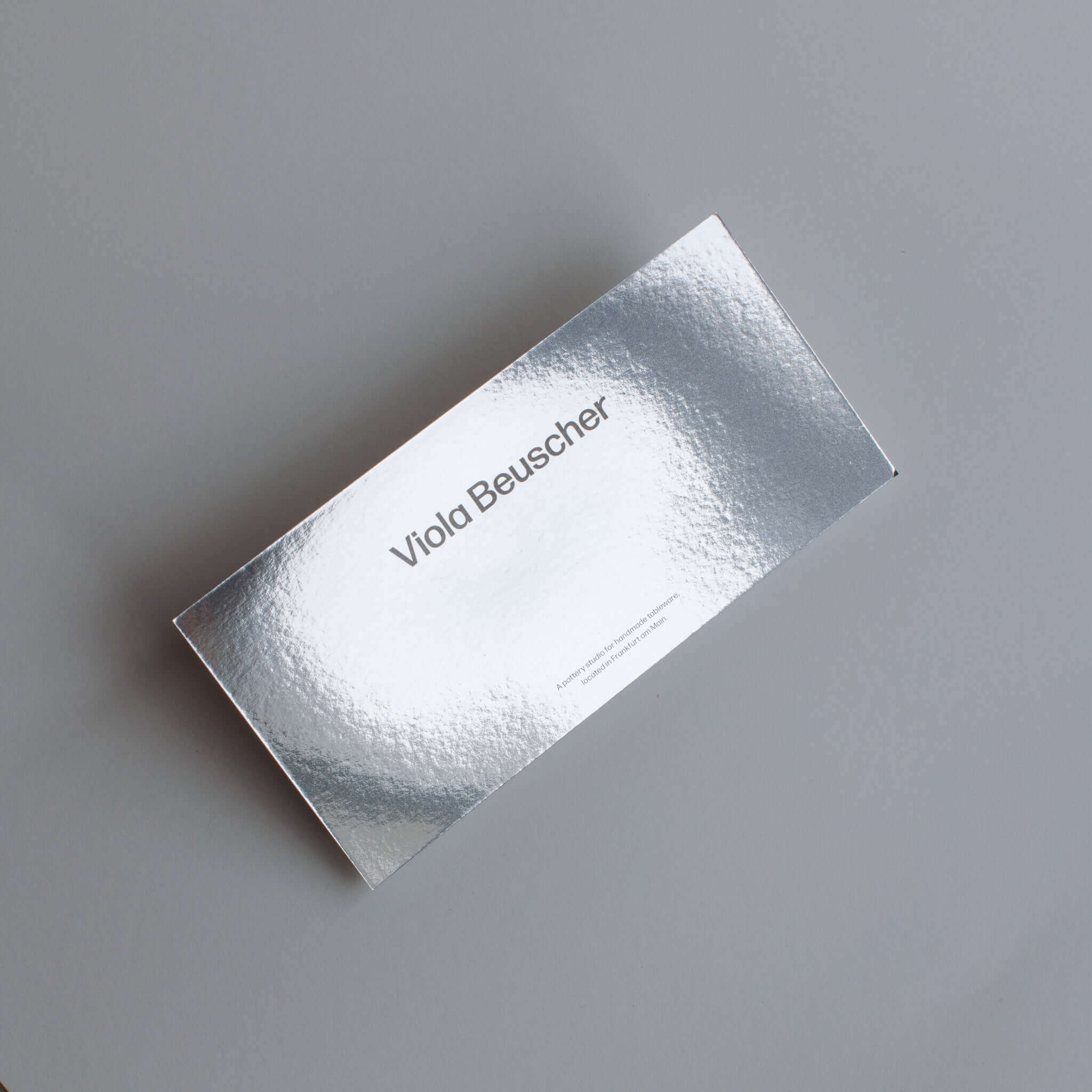 Silver printed gift card featuring the name Viola Beuscher on a textured surface