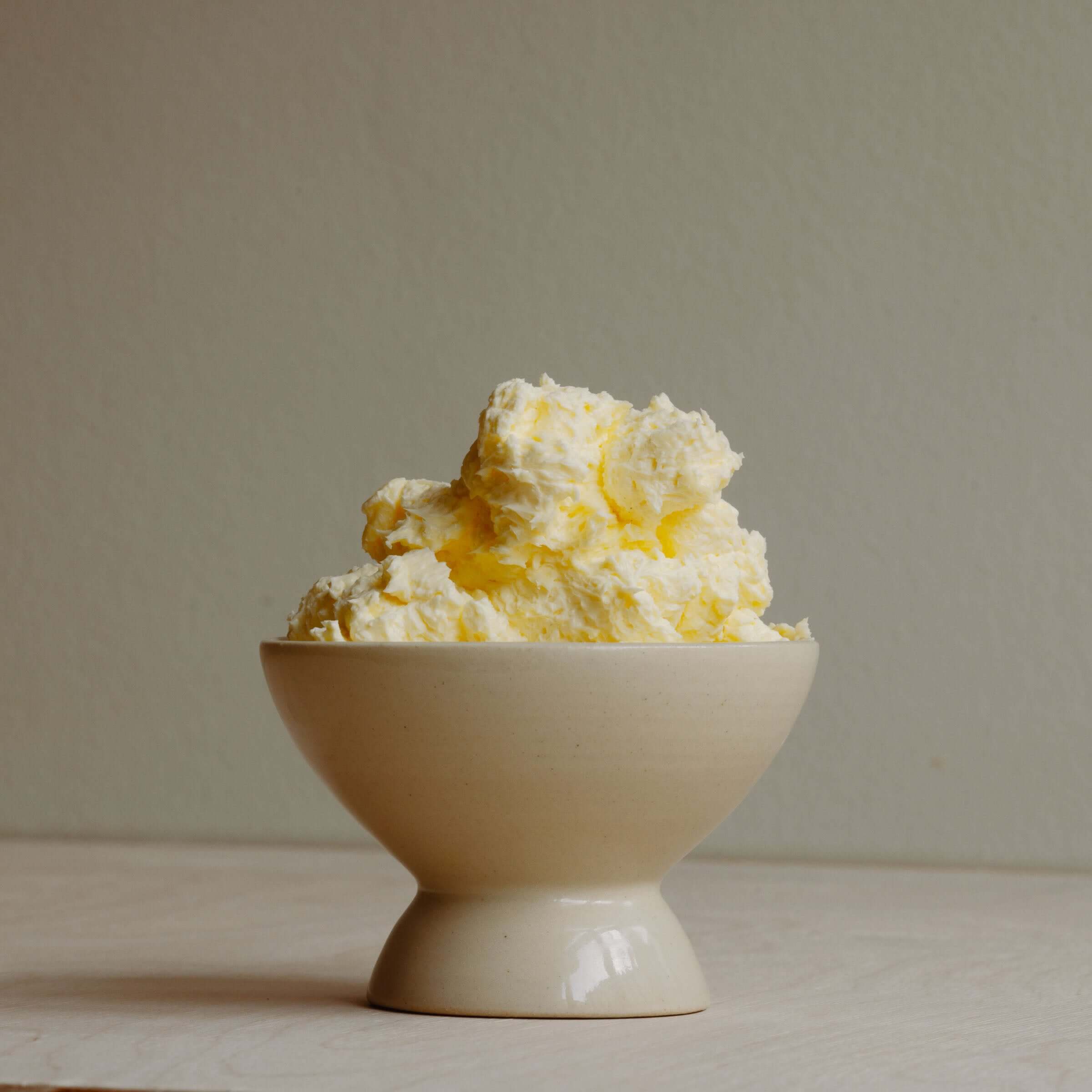A dessert bowl. It looks like a small bowl on top of a smaller upside down bowl. In it is some whipped butter