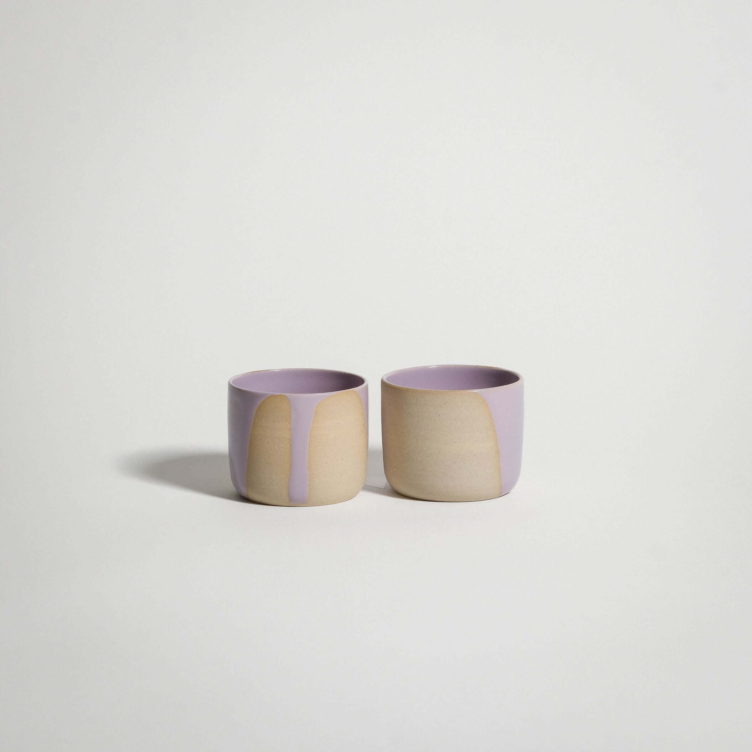 Handcrafted lilac stoneware espresso cups with glossy pink glaze accents, ideal for enjoying espresso or doppio.