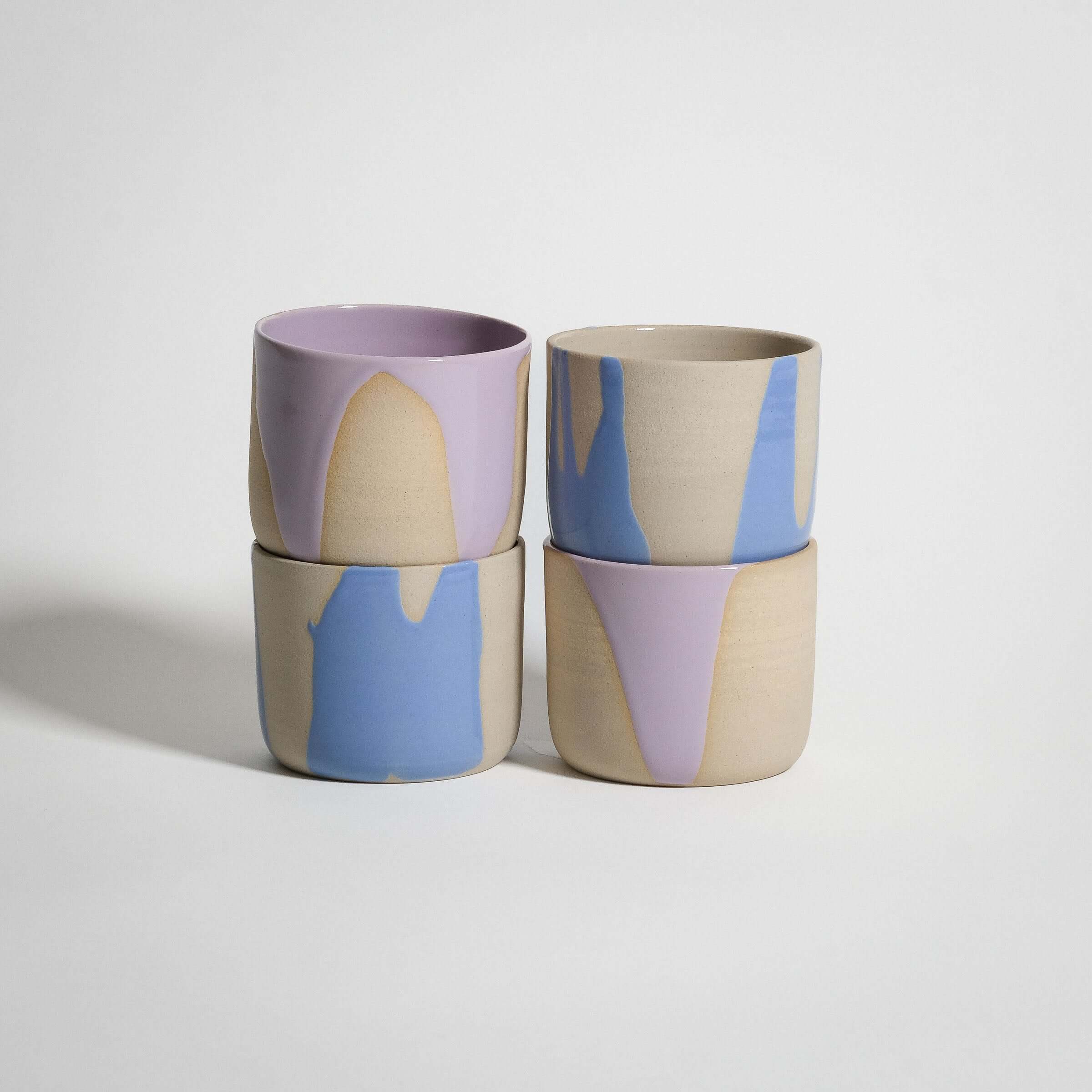 Handcrafted wheel-thrown coffee cup set in grey stoneware with lilac and light blue glossy finishes.