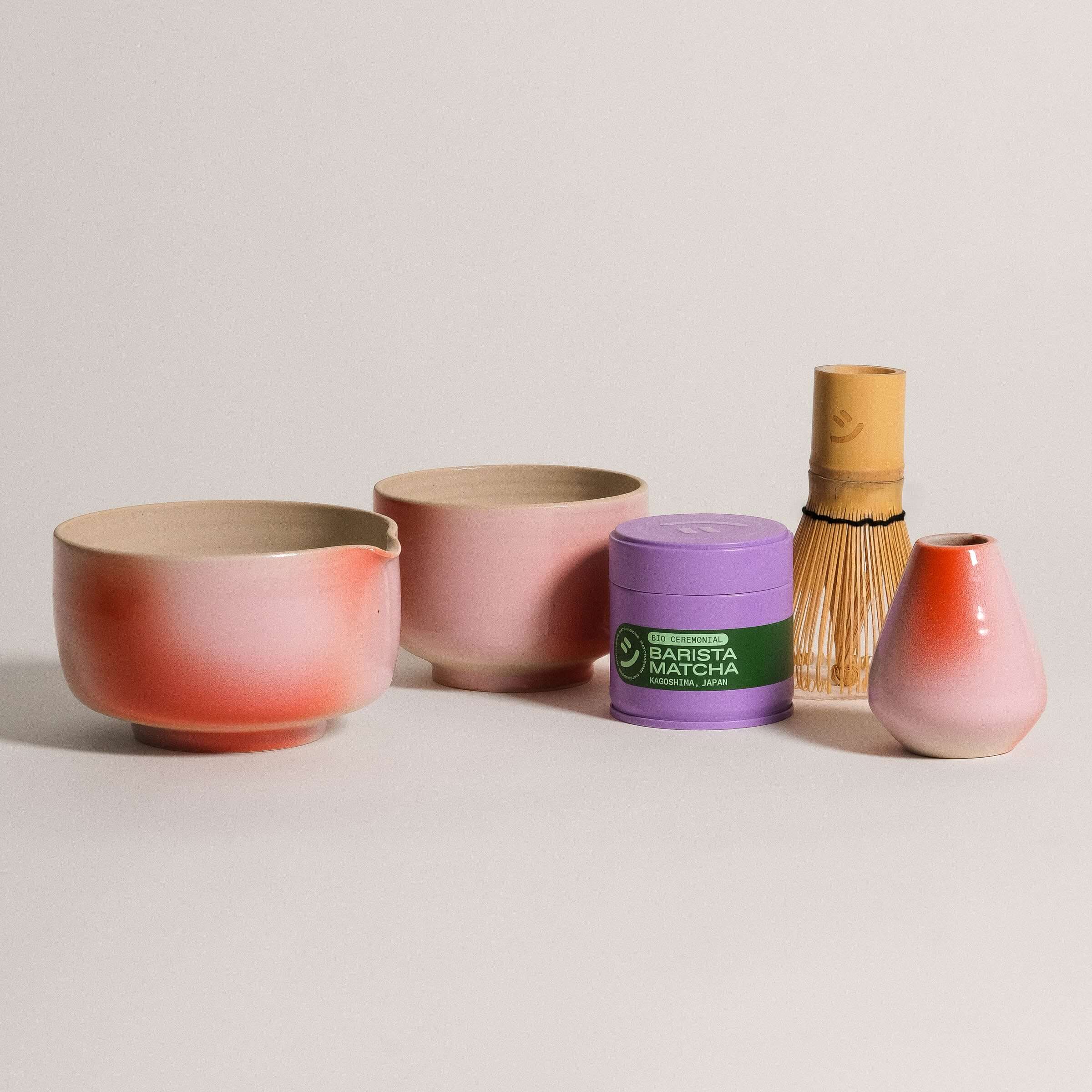 Handcrafted matcha pouring bowl set featuring a gradient finish, alongside matcha powder and whisk.