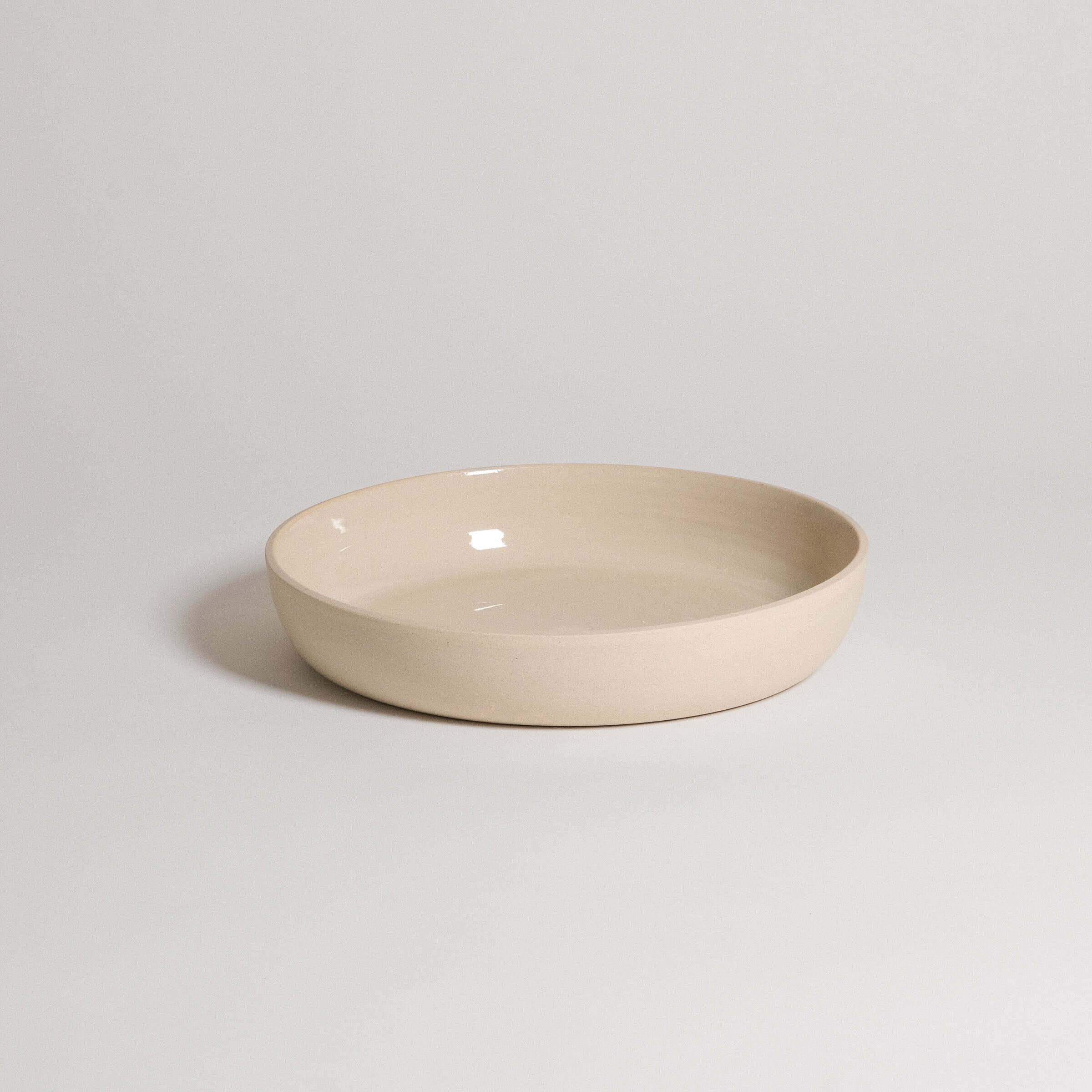 Handcrafted stoneware dinner bowl in creme color, featuring a durable and elegant design for everyday use.