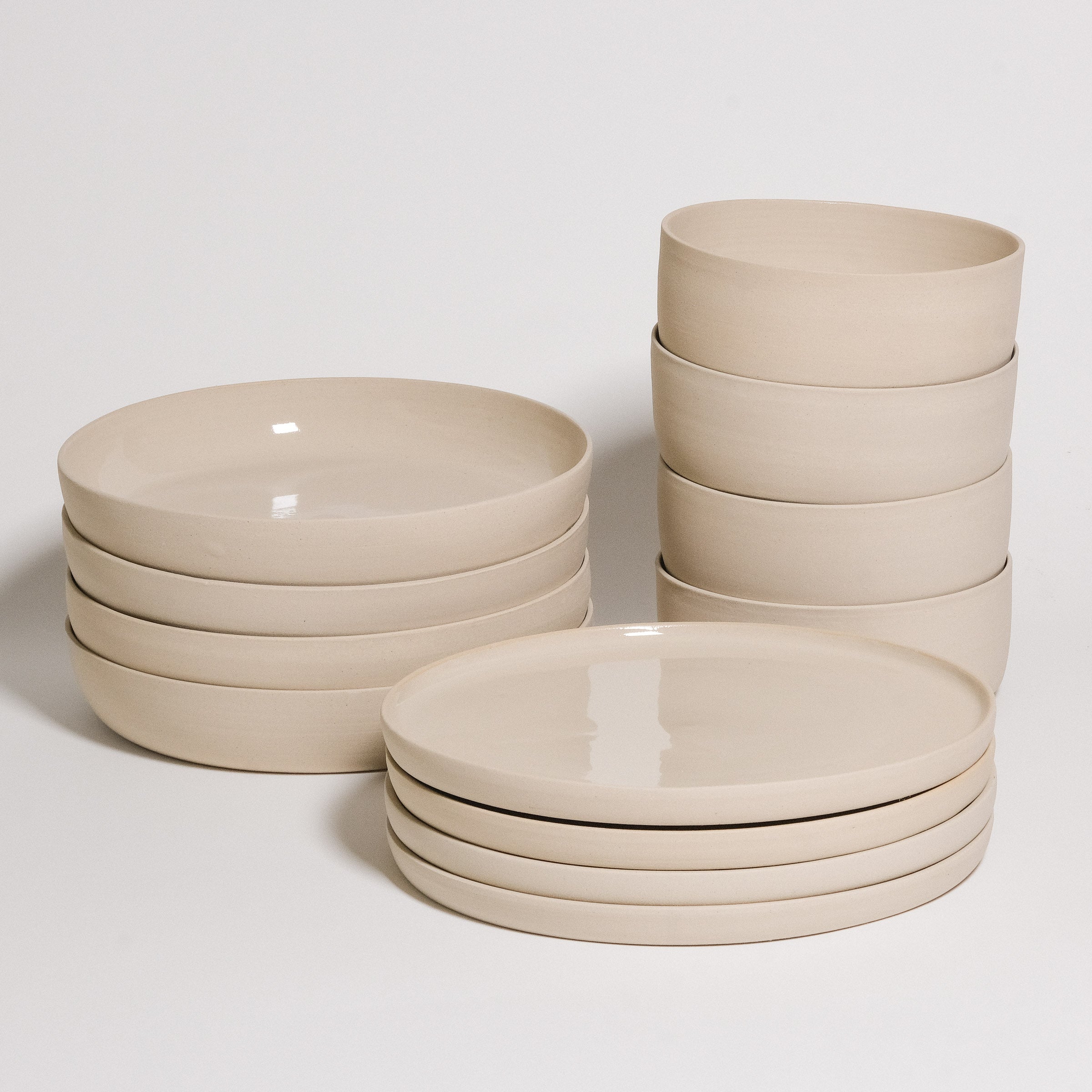 Mix & Match - Tableware Bundle featuring stacked beige plates and bowls for customizable dining experiences.
