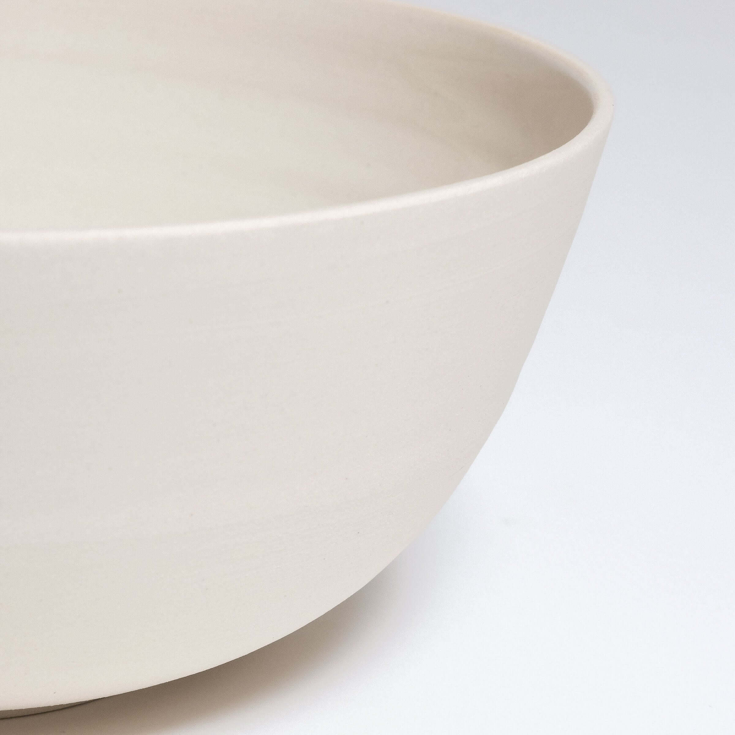 Close-up of a grey stoneware ramen bowl with a glossy glazed inside and a raw finish on the outer surface.