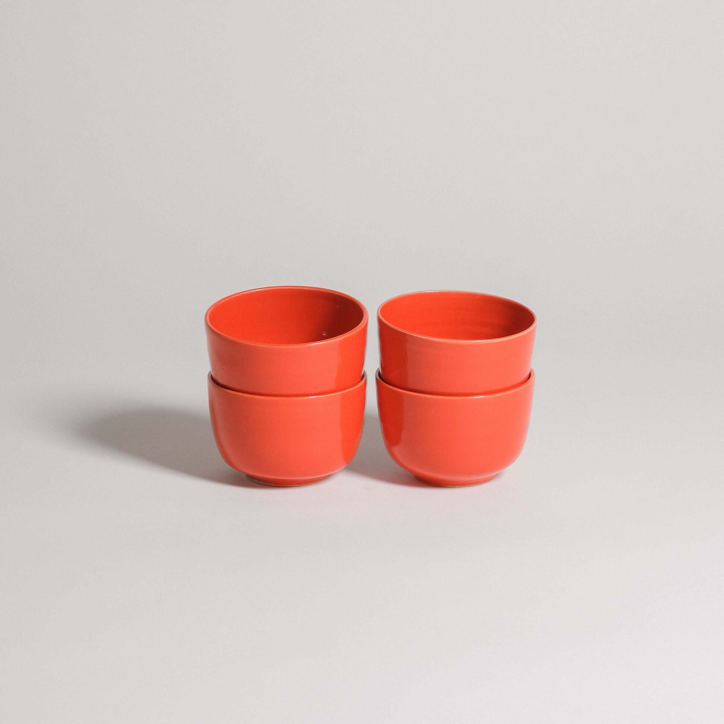 Set of 4 glossy red stoneware flat white cups, perfect for coffee with oat milk.