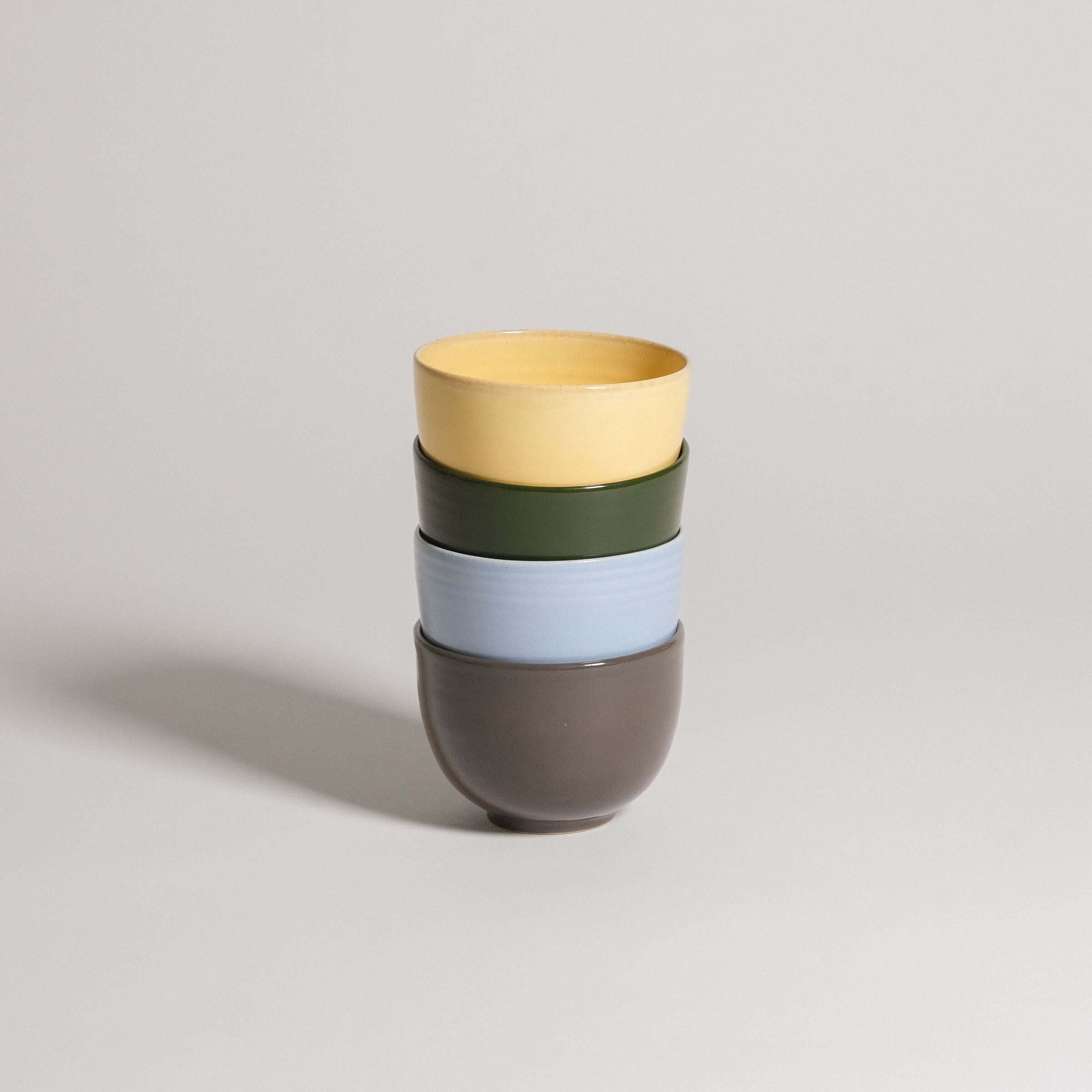 Set of 4 unique coffee cups in yellow, green, ice blue, and brown, handcrafted ceramic, dishwasher and food-safe.