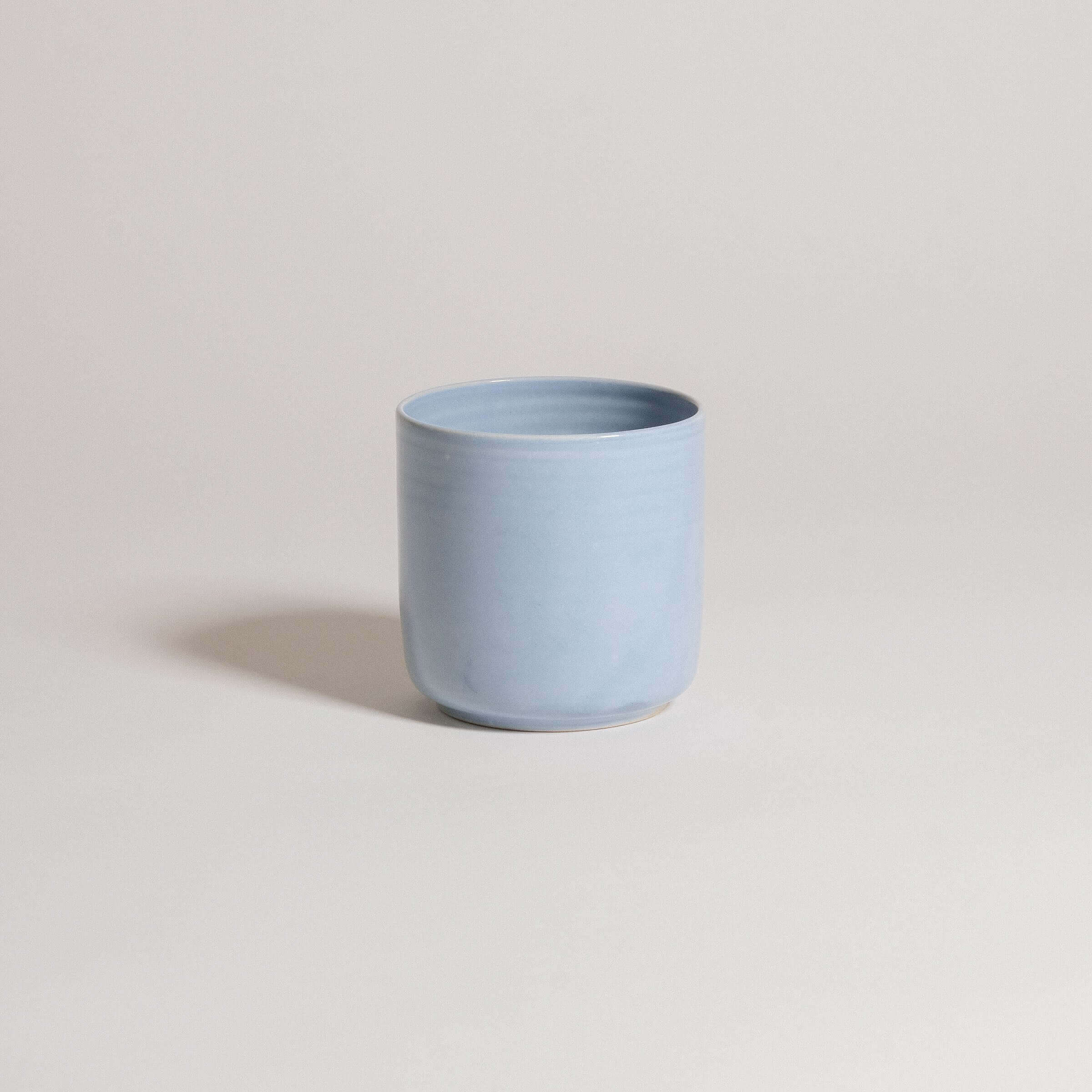 Handcrafted iceblue tea cup from the Nomi collection, made of durable stoneware ceramic, showcasing unique design.