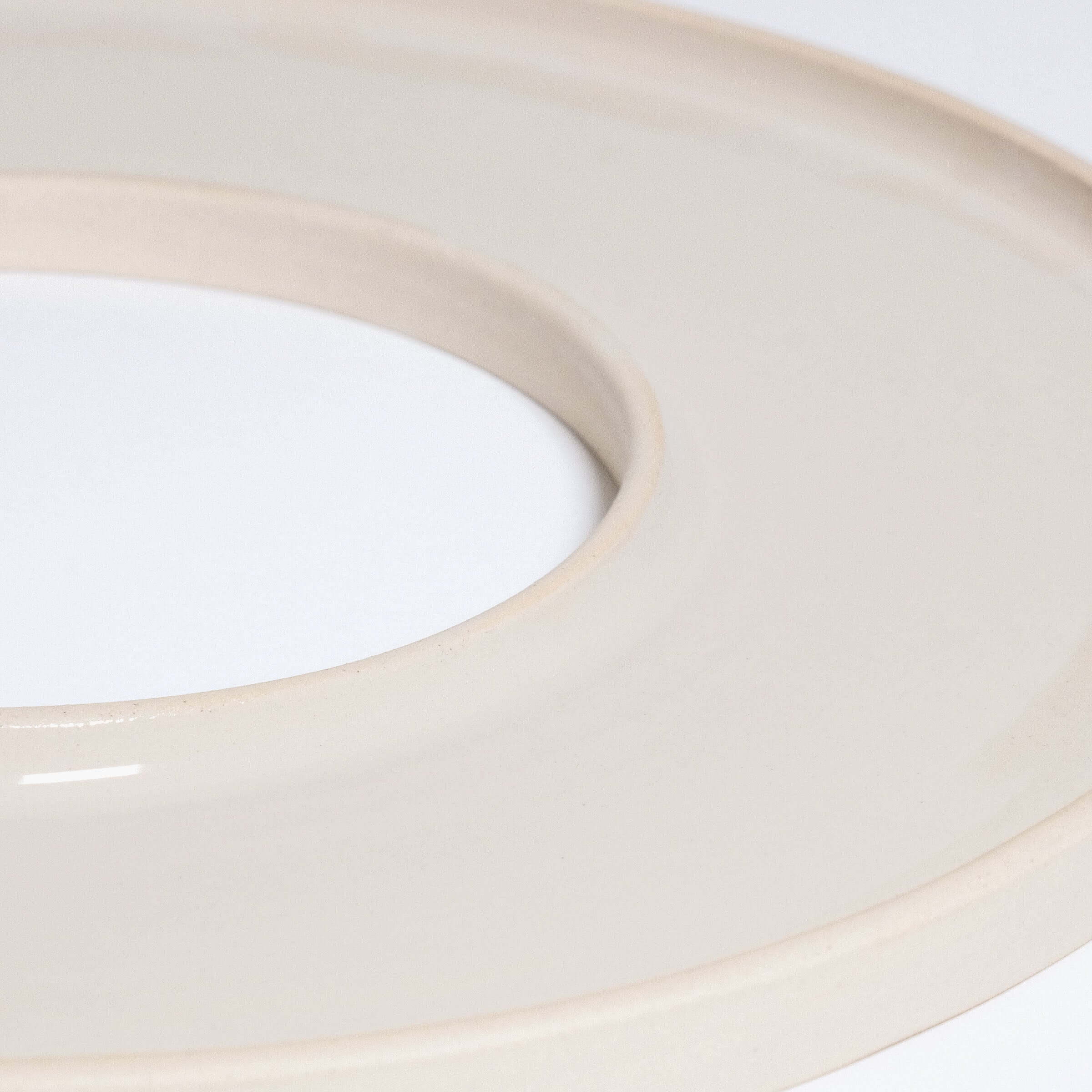 Handgefertigtes Tapas-Tablett in Creme mit glänzender Glasur und rohem Ton außen.