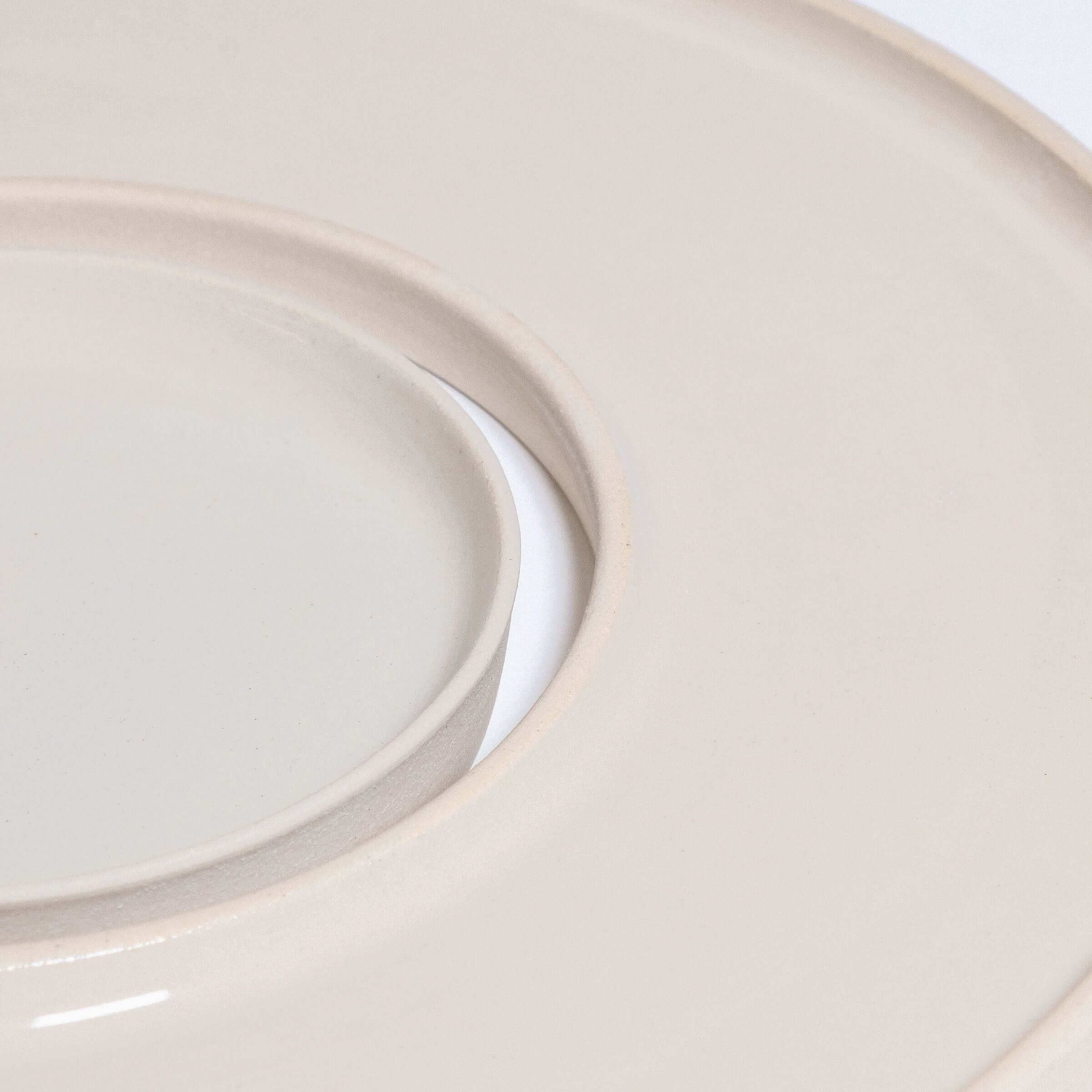 Close-up of a cream-colored tapas tray set, highlighting its smooth glossy finish and circular design.