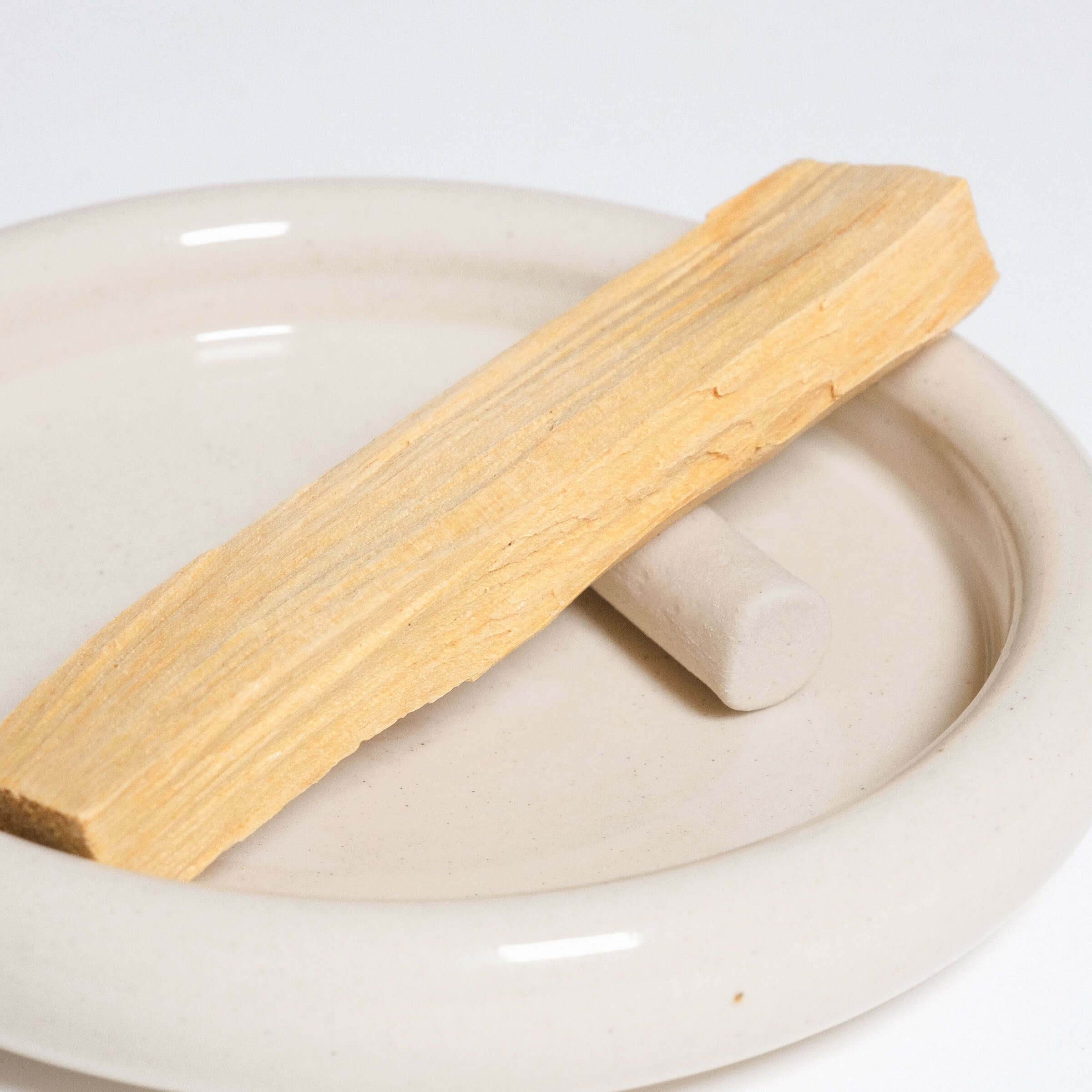 Palo Santo set featuring a grey stoneware dish, Palo Santo stick, and unique small holder for wood.