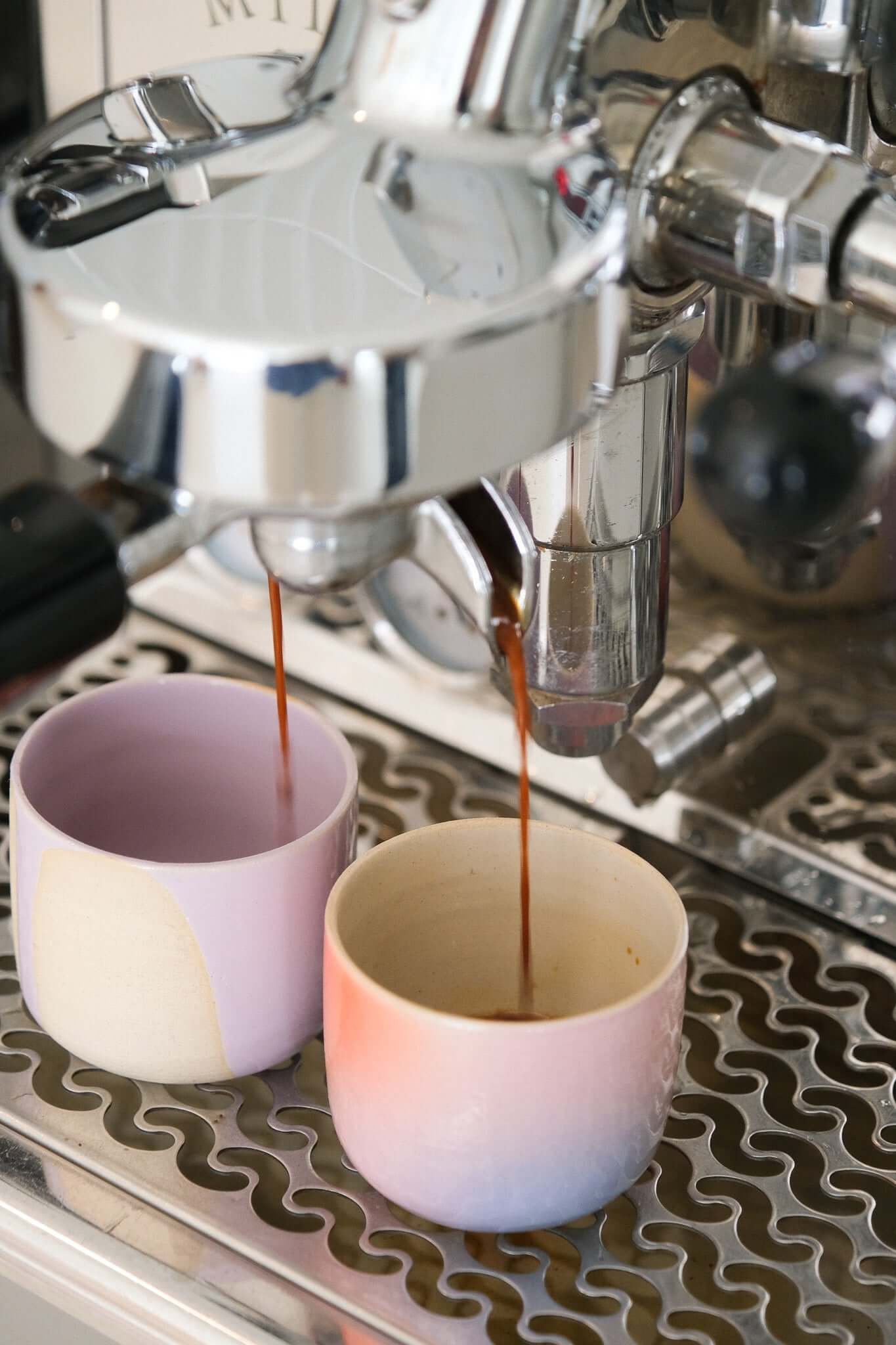 Coffee espresso brewing into colorful cups, showcasing the joyful spirit of the Happy Edition collection.