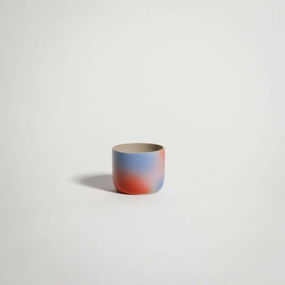 Dawn Espresso Cup handcrafted from grey stoneware with a glossy glaze and red-blue-lilac gradient exterior.