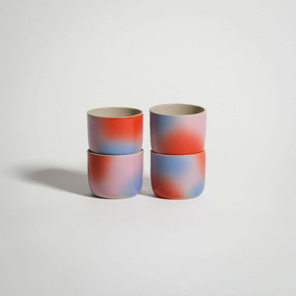 Handcrafted grey stoneware espresso cups with red, blue, and lilac gradient finish.