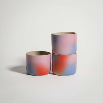 Handcrafted Dawn Coffee Cup set in grey stoneware with glossy glaze and gradient colors in red, blue, and lilac.