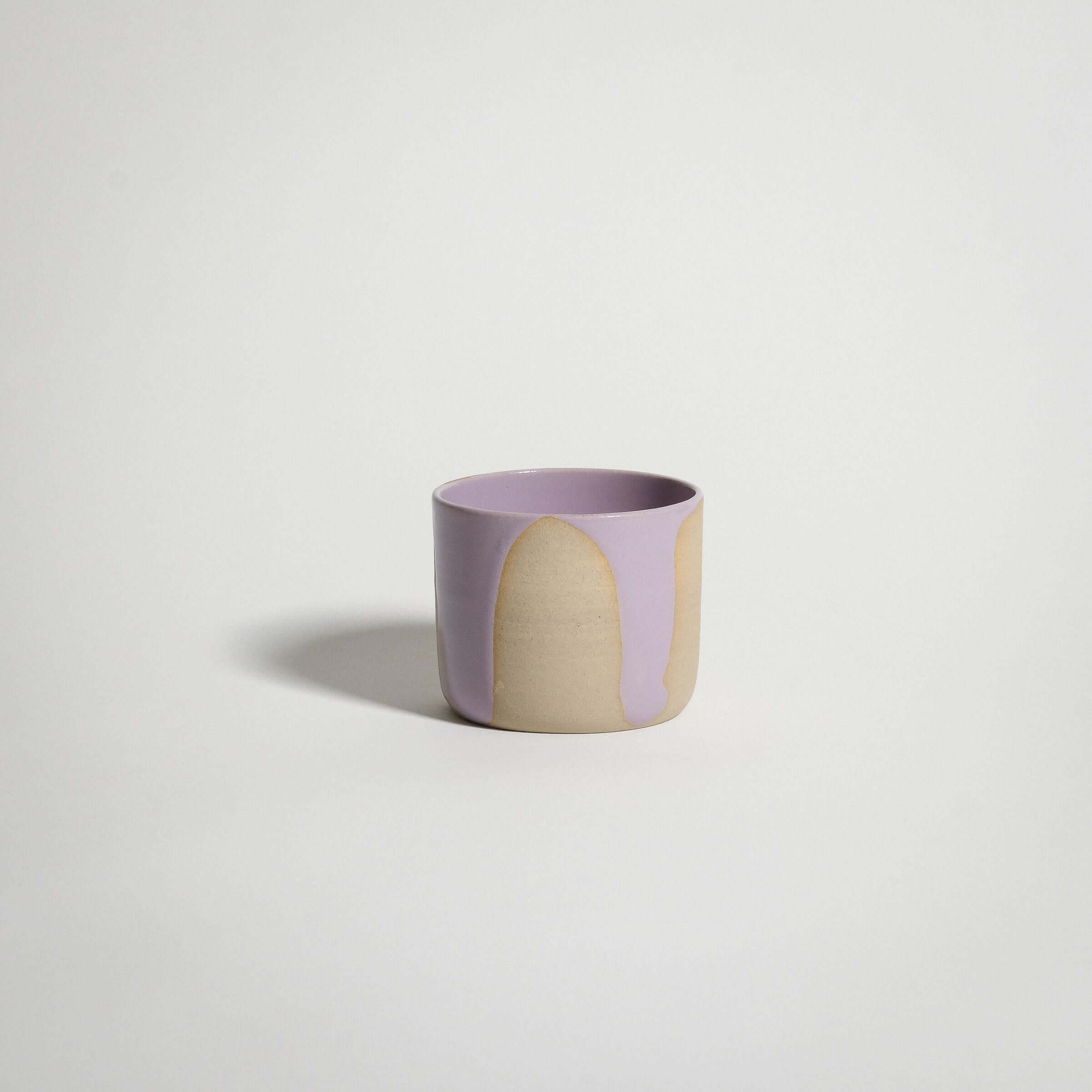 Handcrafted wheel-thrown lilac coffee cup in grey stoneware with pink glossy exterior glaze.