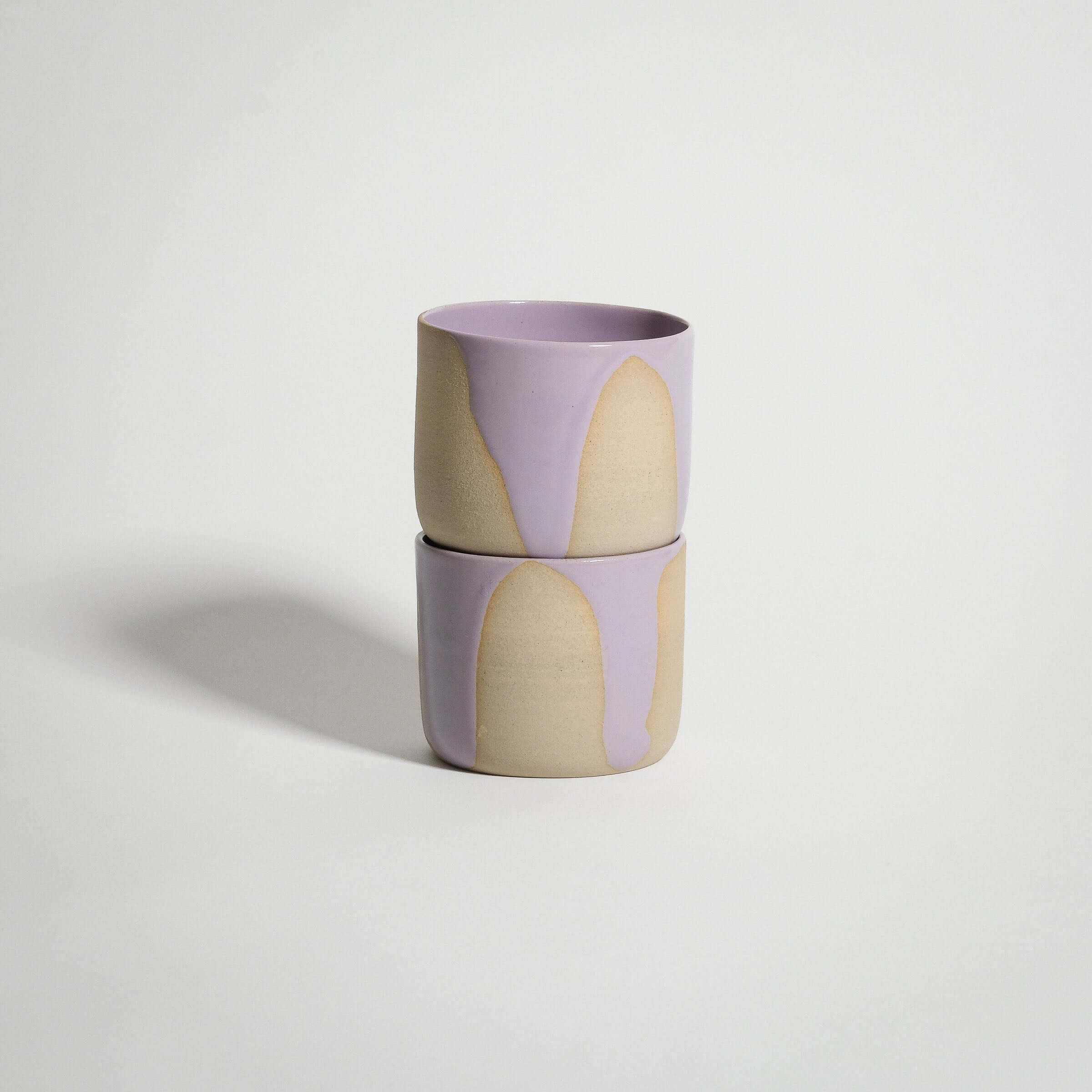 Handcrafted wheel-thrown lilac coffee cup with pink glossy glaze, ideal for tea or warm beverages.