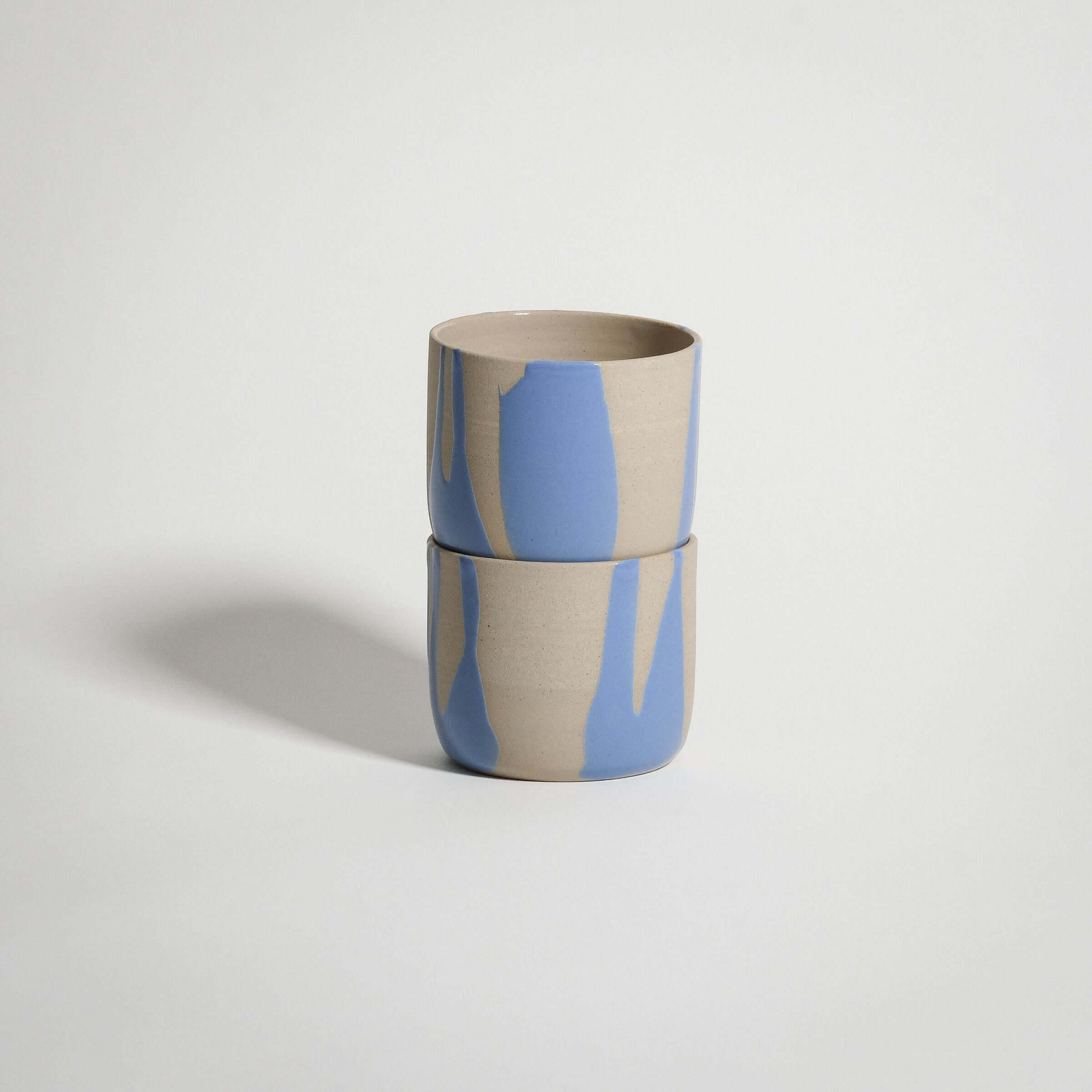 Handcrafted wheel-thrown blue stoneware coffee cup with glossy glaze, ideal for warm beverages.