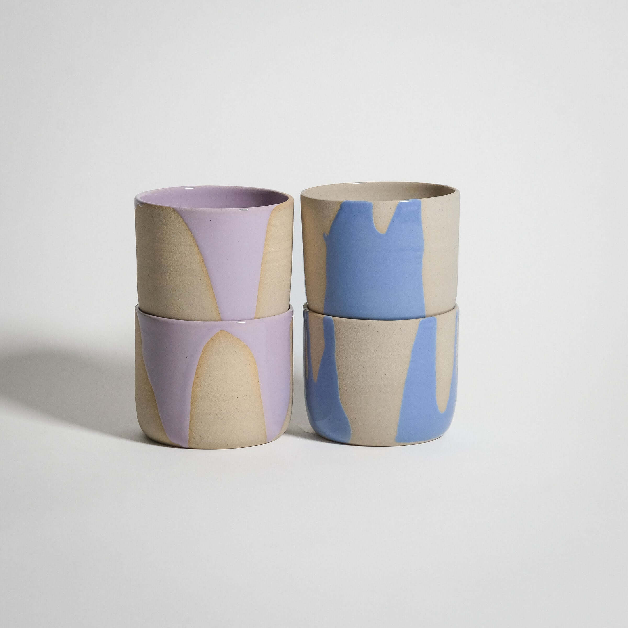 Handcrafted grey stoneware coffee cup set featuring lilac and light blue glossy finishes.