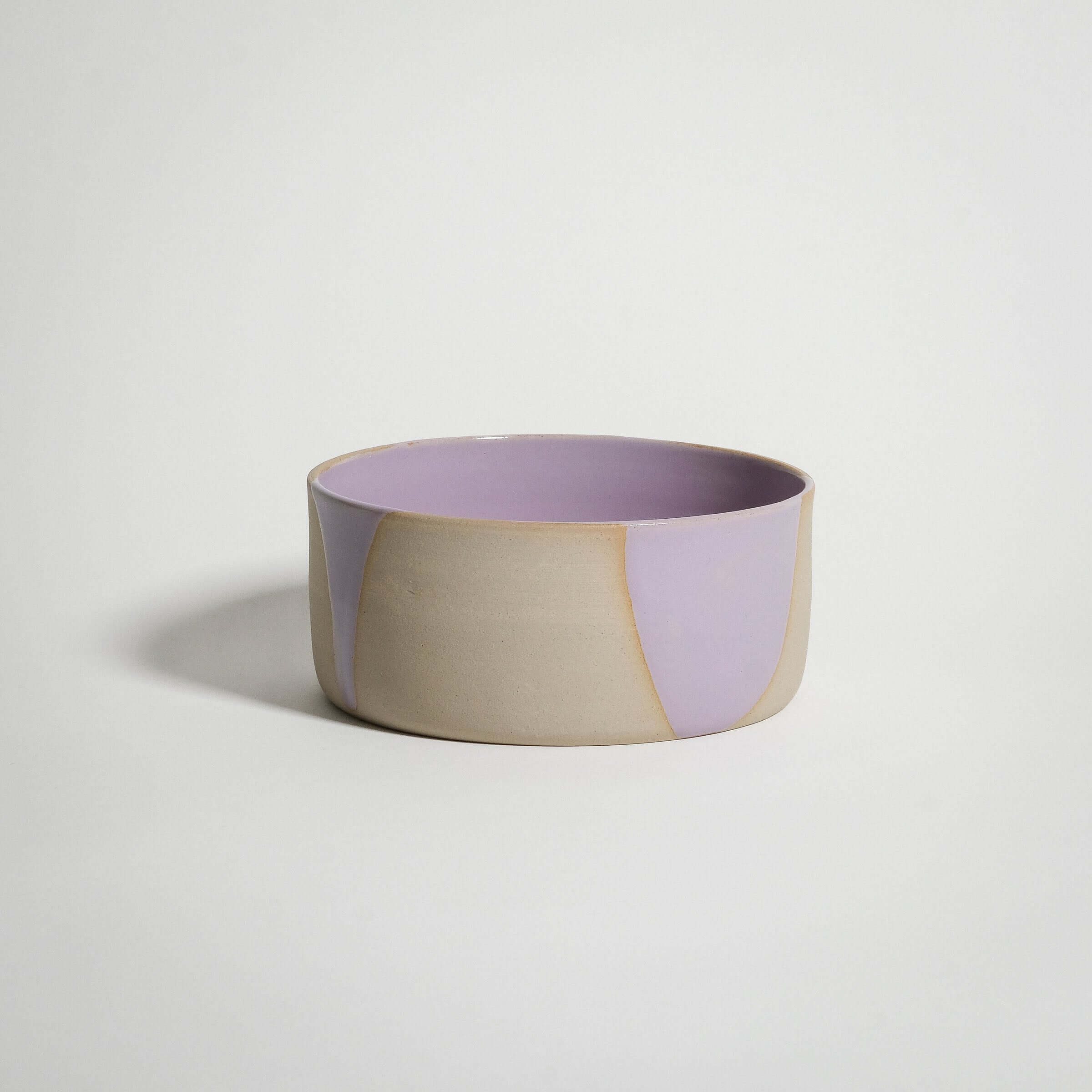 Handcrafted lilac splash breakfast bowl with glossy pink glaze interior and grey stoneware exterior.