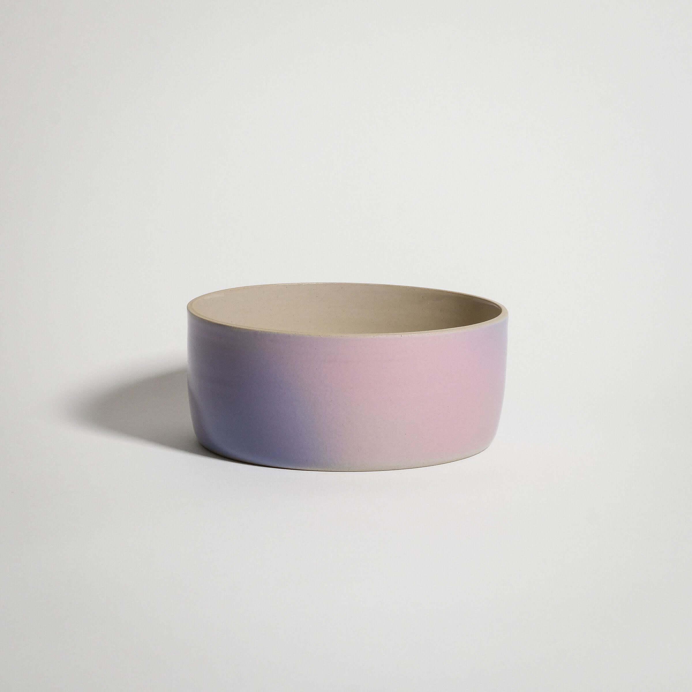 Handcrafted grey stoneware breakfast bowl with glossy pink and lilac fade glaze.