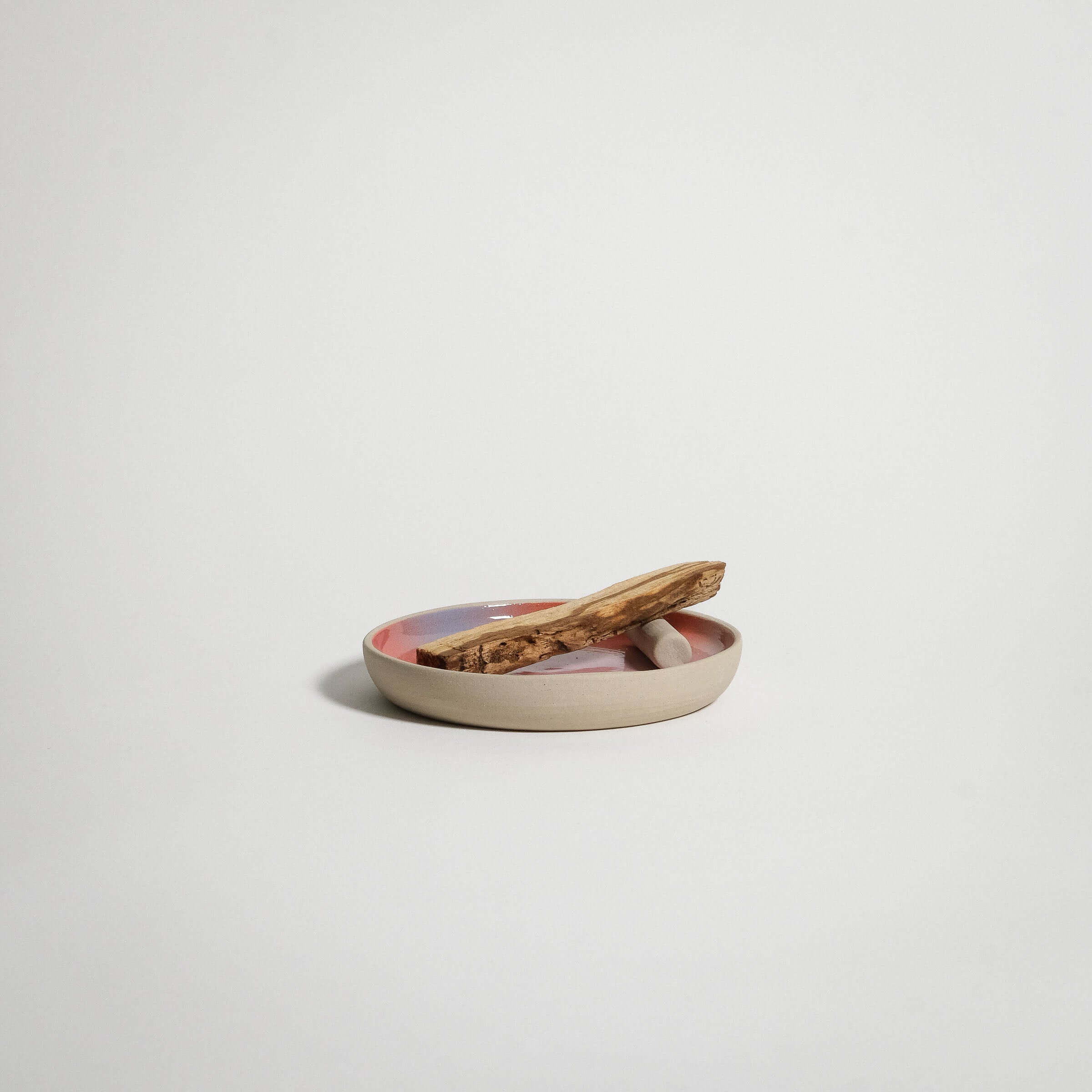 Handcrafted grey stoneware small plate with red, blue, and lilac gradient, featuring palo santo stick.