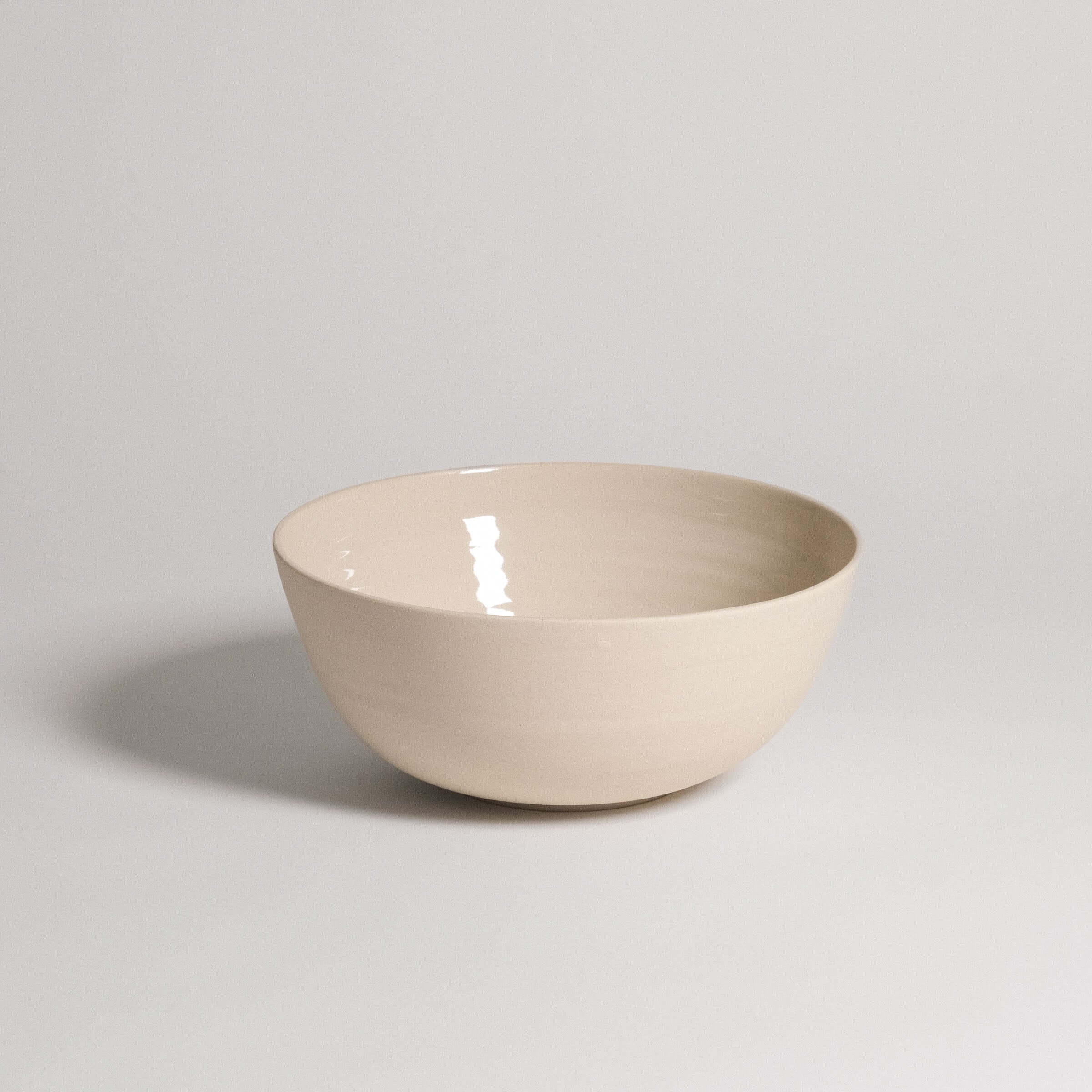 Ramen bowl in creme color, made of grey stoneware with glossy glaze inside and raw finish outside.