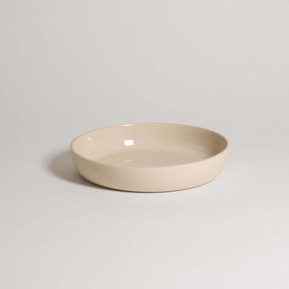 Handcrafted stoneware dinner bowl in creme color, featuring a durable and elegant design for everyday use.