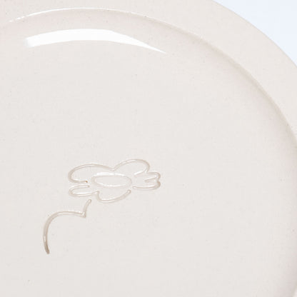Close-up of neo creme bistro plate showcasing embossed logo and smooth glaze finish on durable stoneware.