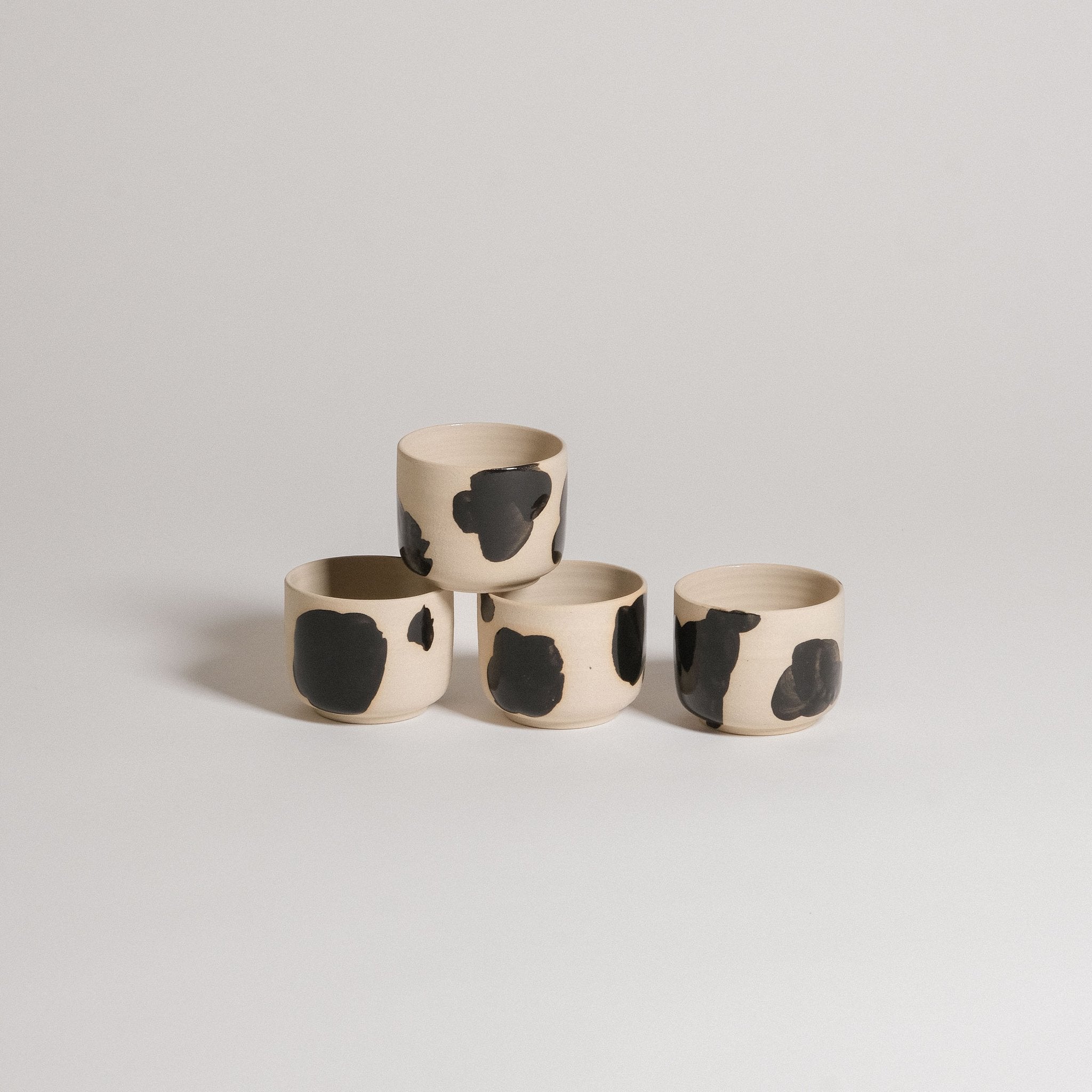 Mix & Match - Cup & Mug Bundle featuring four unique ceramic cups with black and beige designs.