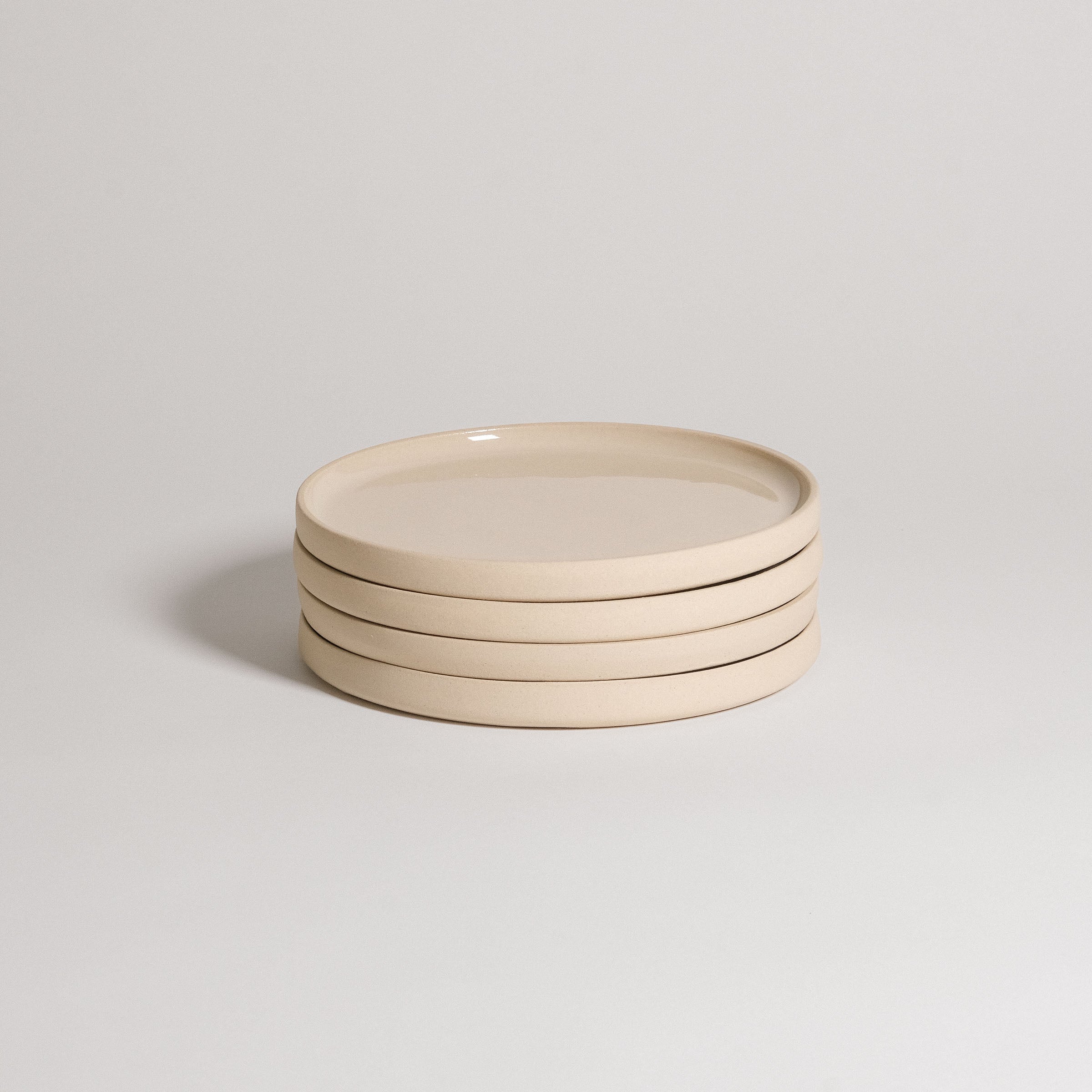 Mix & Match - Plate Bundle of four elegant beige plates stacked together, perfect for customizable tableware.