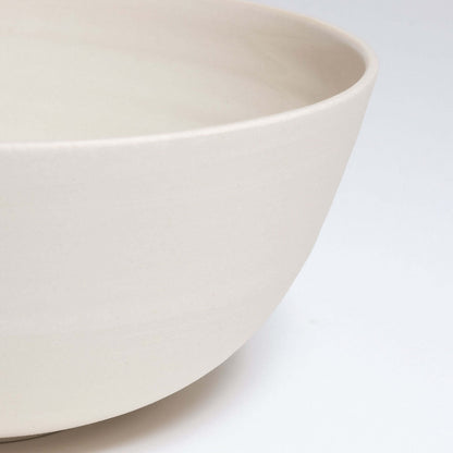 Close-up of a grey stoneware ramen bowl with a glossy glazed inside and a raw finish on the outer surface.