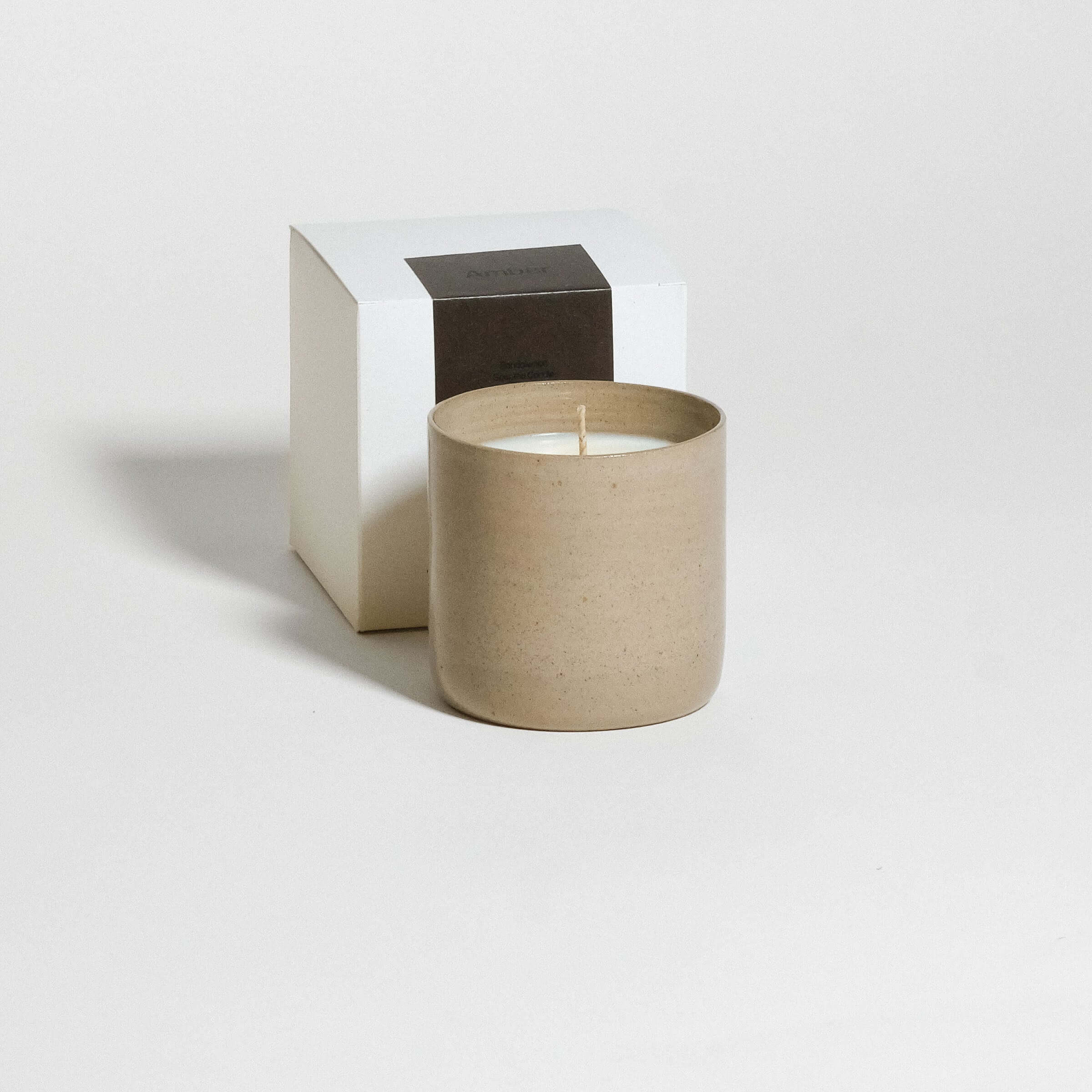 Duftkerze Sandelholz in braunem Steinzeugbecher mit Verpackung, 225 g und 55 Stunden Brenndauer.