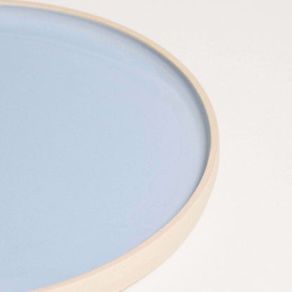 Close-up of Iceblue breakfast plate, showcasing smooth glazed interior and natural raw edge.