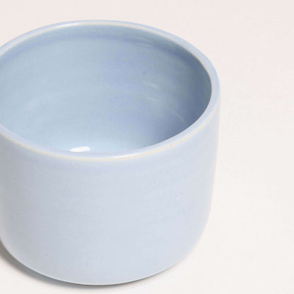 Handcrafted stoneware coffee cup in Iceblue glaze, durable and unique, perfect for dishwasher and oven use.