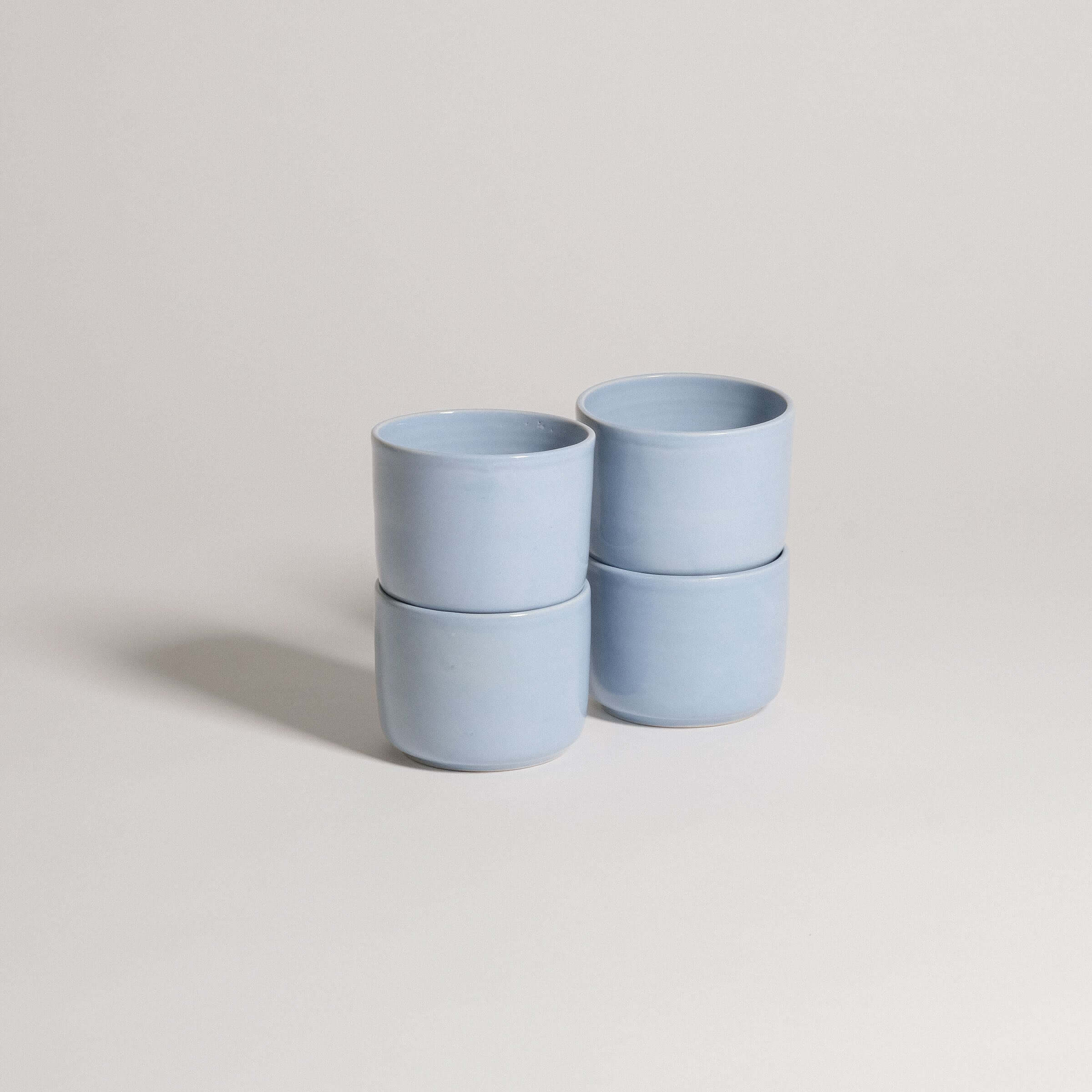 Set of 4 Nomi Iceblue coffee cups, handcrafted stoneware ceramic, showcasing unique iceblue glaze finish.