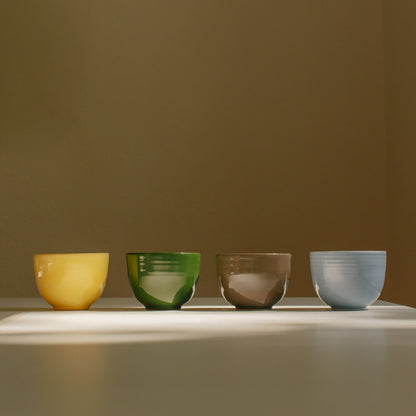 Set of 4 handcrafted stoneware coffee cups in yellow, green, brown, and ice blue, highlighting ceramic beauty.