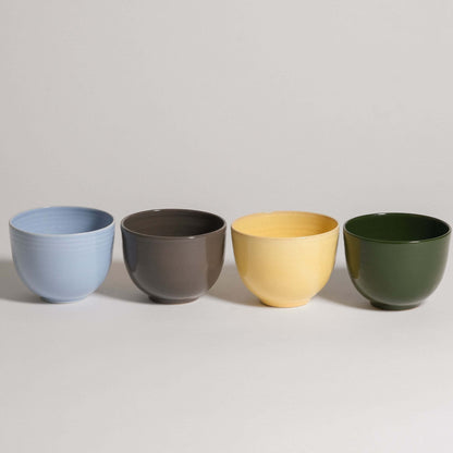 Set of 4 handcrafted stoneware coffee cups in iceblue, brown, yellow, and green for stylish beverage enjoyment.