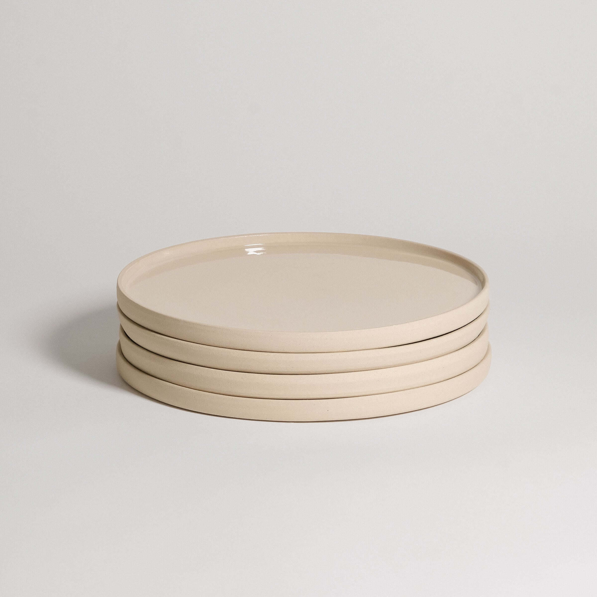 Set of 4 handcrafted creme dinner plates made from durable stoneware ceramic, featuring a unique transparent glaze.