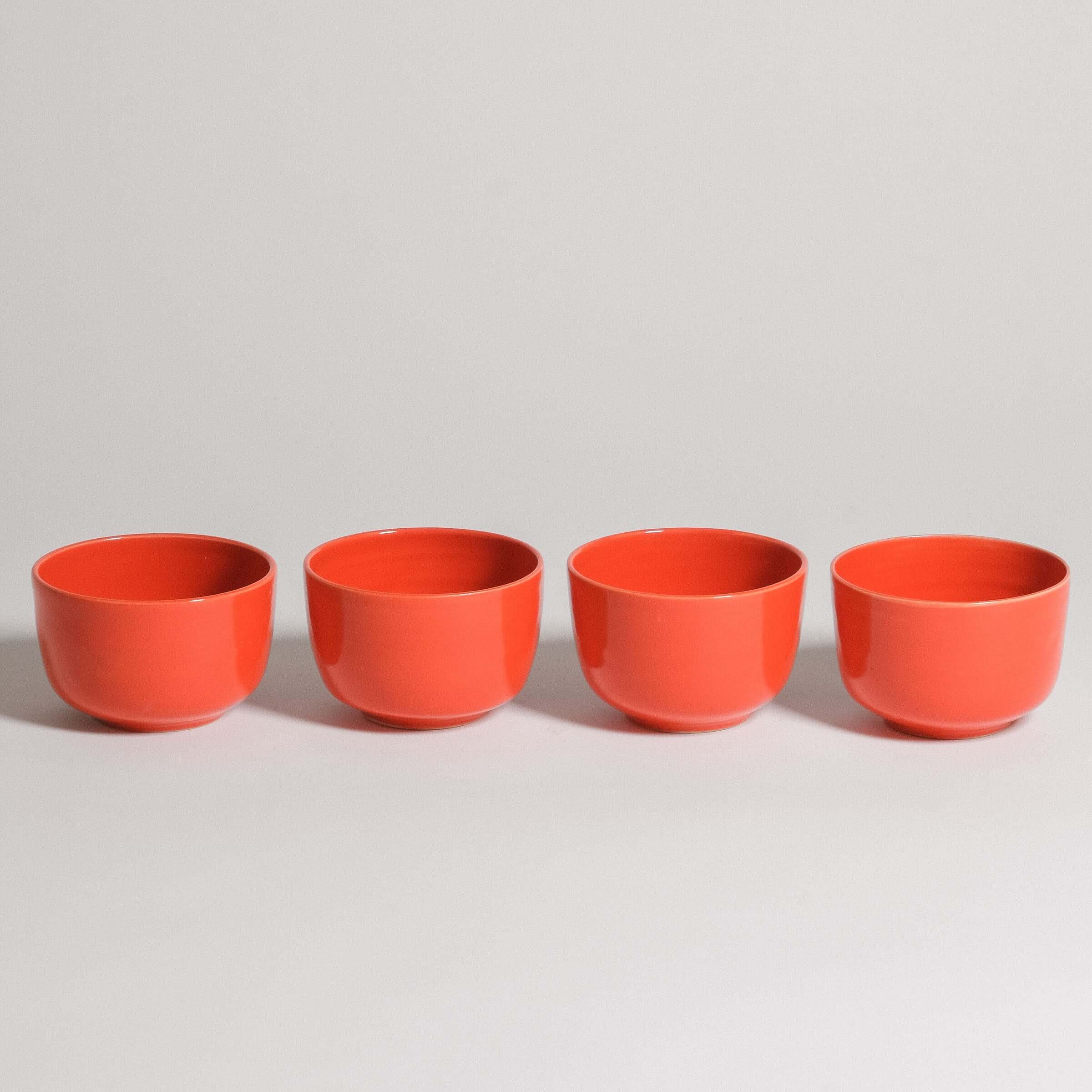Set of 4 flat white cups in glossy red glaze, made from grey stoneware clay, perfect for coffee drinks.