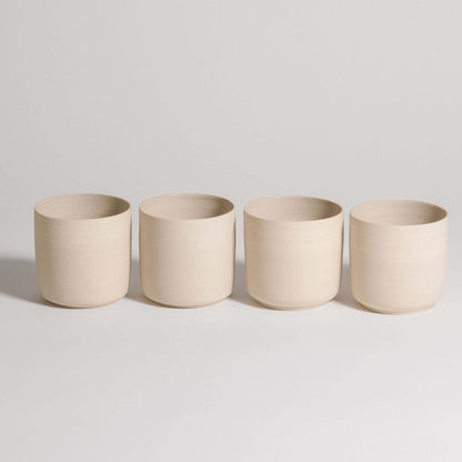 Set of 4 tea cups in Nomi Creme, crafted from grey stoneware with a glossy interior and raw exterior finish.