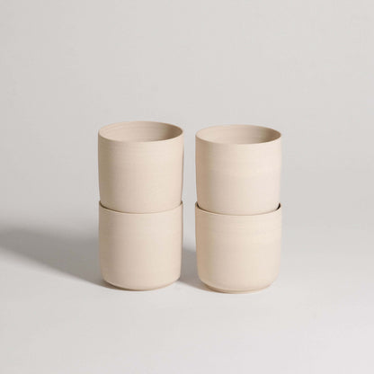 Set of 4 Nomi Creme tea cups made of grey stoneware with glossy interior and raw exterior finish.