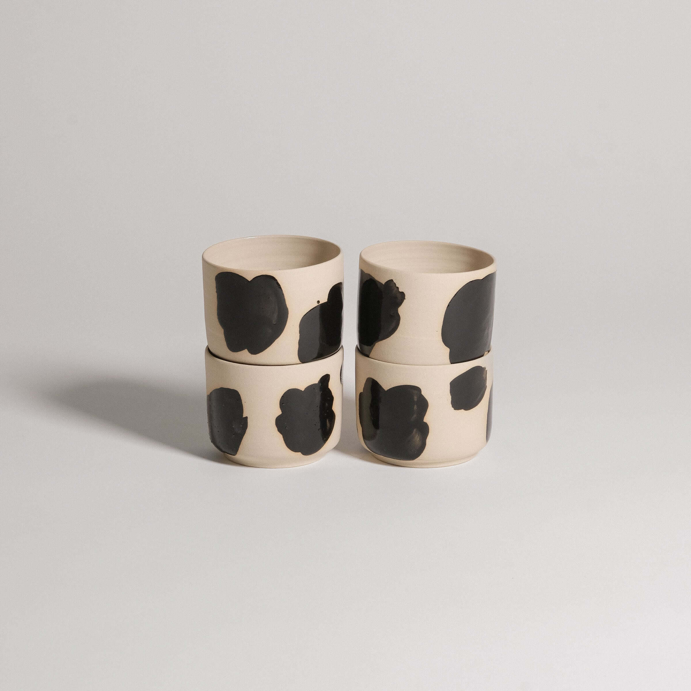 Set of 4 wheel-thrown coffee cups in grey stoneware, hand-painted glossy black brush strokes on the exterior.
