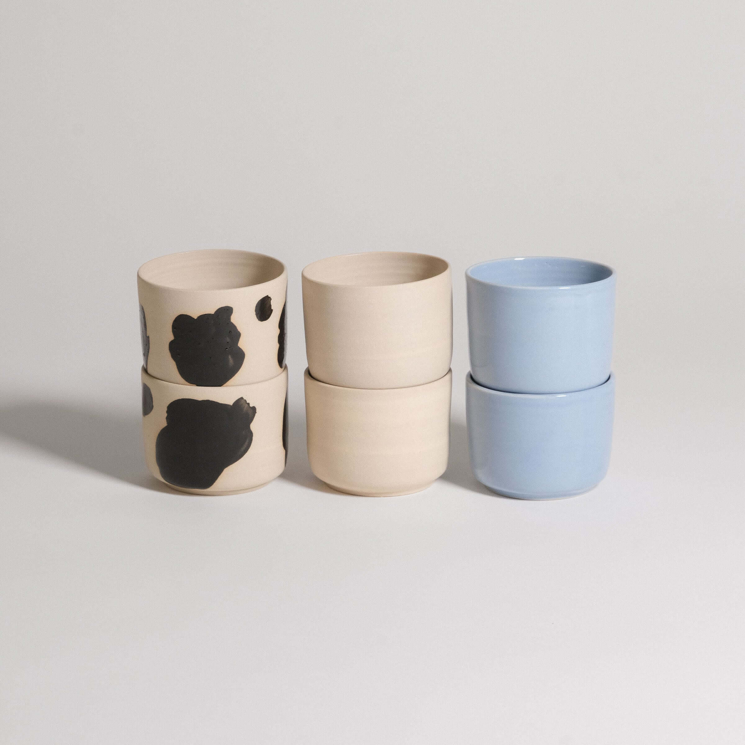 Mix & Match - Cup & Mug Bundle featuring stacked cups in black and blue glazes for personalized styles.