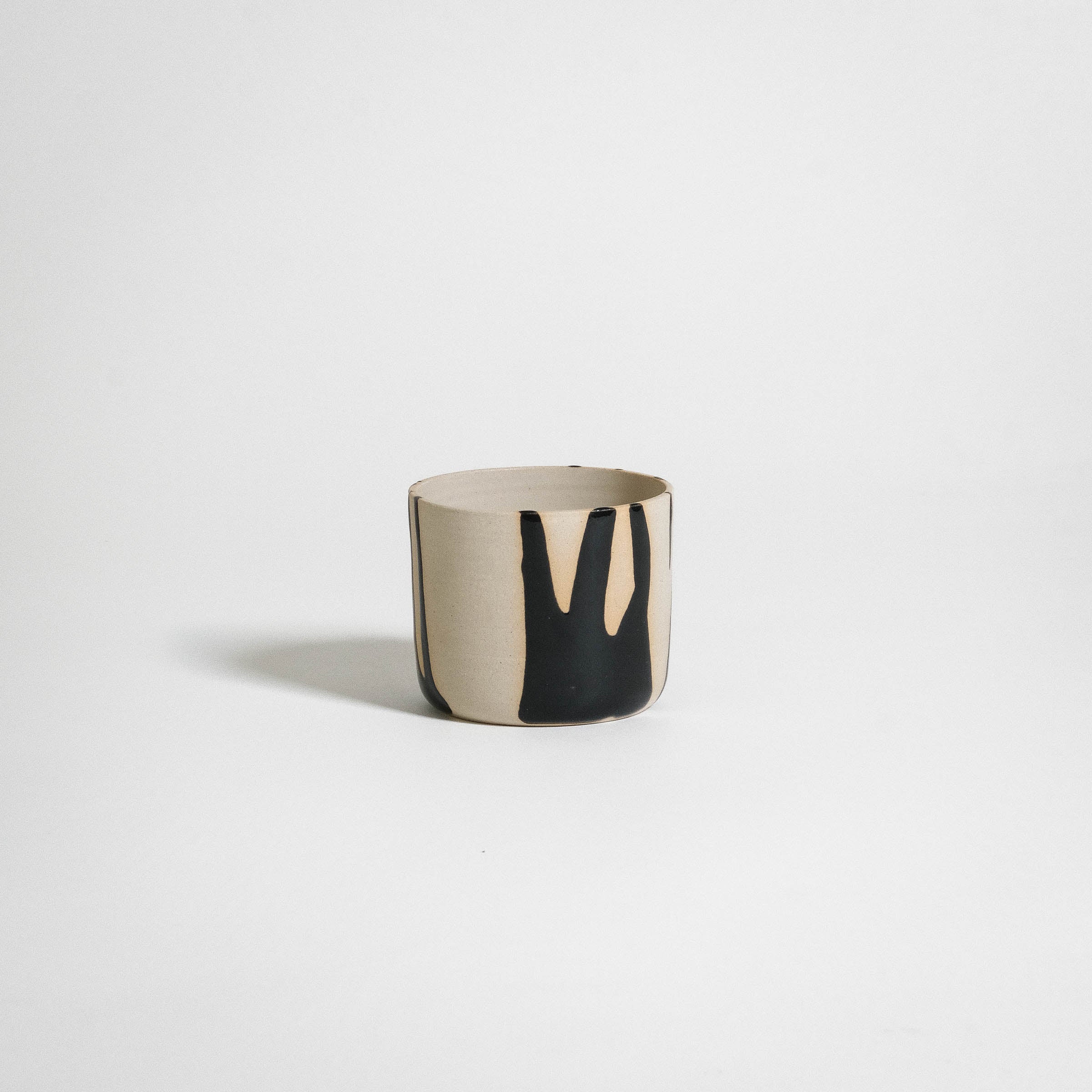 Handcrafted coffee cup in stoneware with glossy black finish and natural clay texture, perfect for daily use.